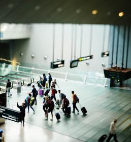 A group of travelers wheel their suitcases through an airport