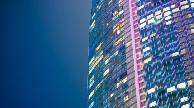 A modern tower block lit up at night
